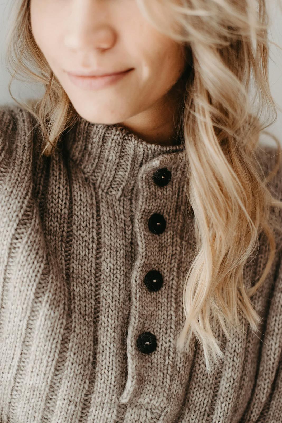 Close-up of the Aeternum Sweater collar in taupe with a double-knit button band and four black buttons.